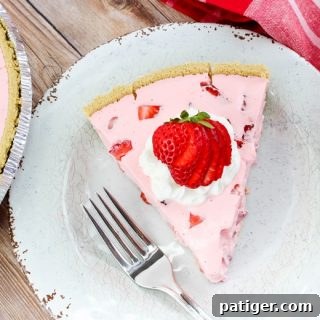Slice of Strawberry Jello Pie on white plate, garnished with whipped cream and strawberries