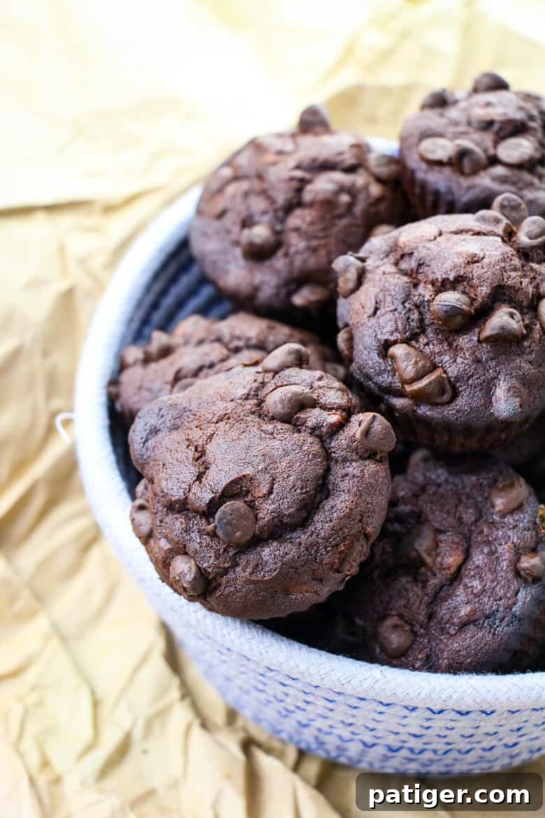 Decadent Double Chocolate Banana Muffins 2 Double chocolate banana muffins in woven bowl.