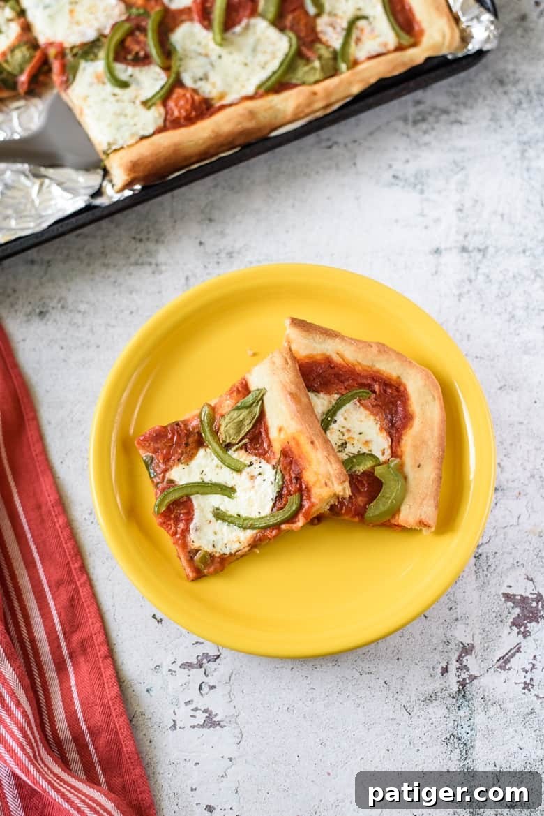 Effortless Sheet Pan Pizza 6 Golden-brown slices of Sheet Pan Pizza arranged invitingly on a yellow plate.