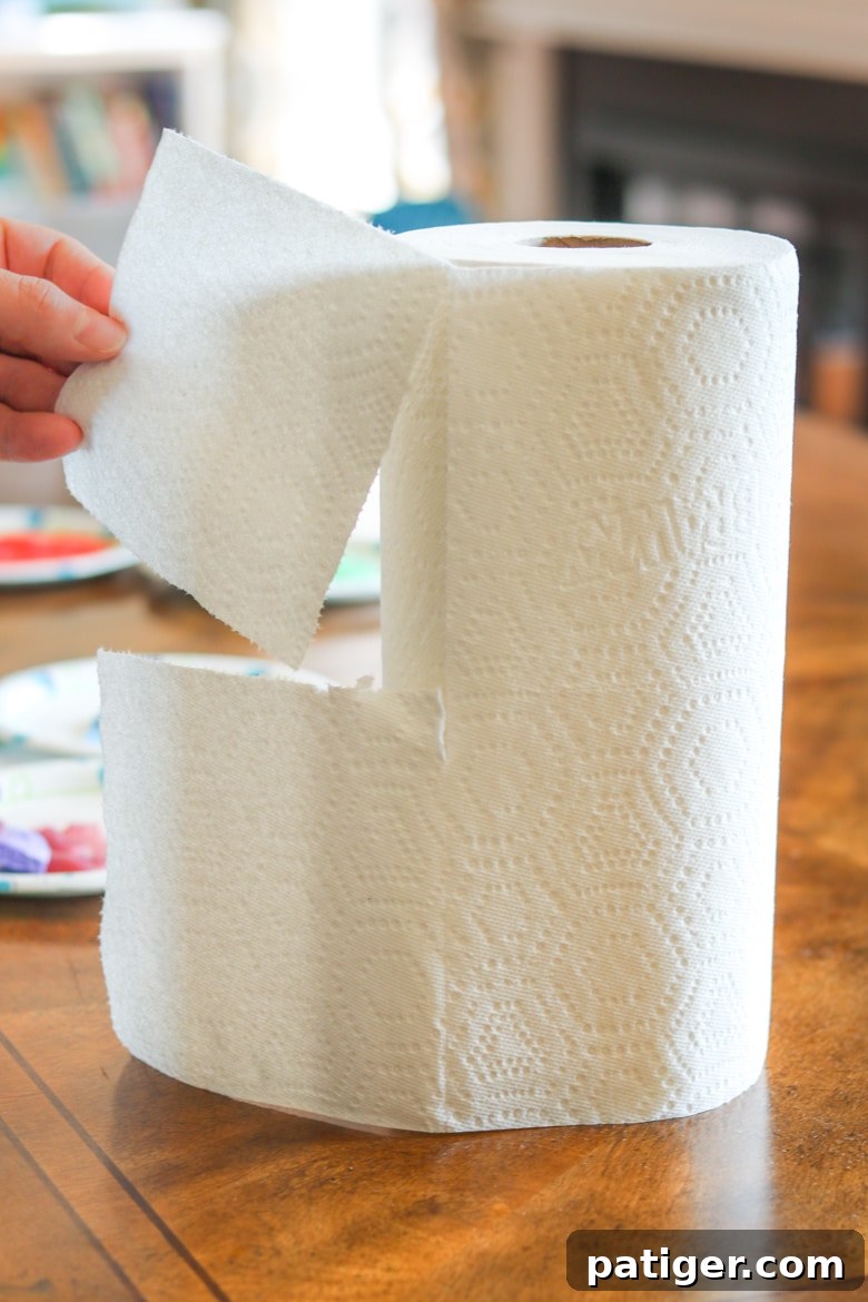Hands demonstrating tearing a Brawny® Tear-A-Square® paper towel into a smaller, quarter-size piece, showcasing its versatile tear options.