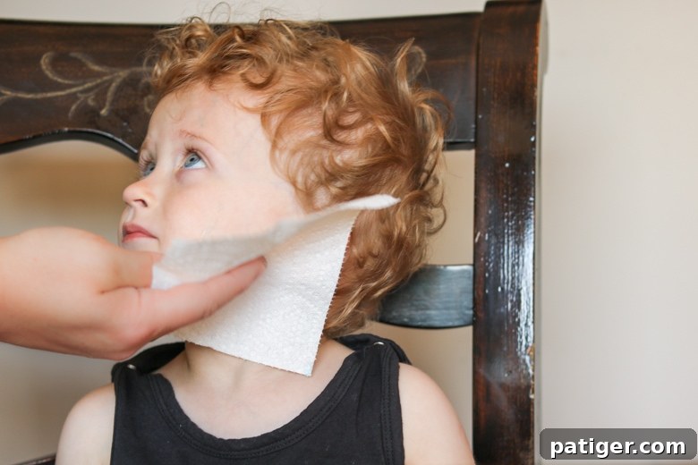 A Brawny® Tear-A-Square® paper towel gently wiping paint from a child's face, showcasing its softness and effectiveness for delicate areas.