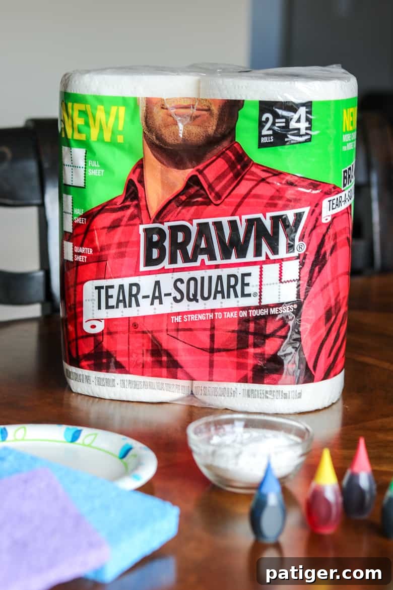 Collection of supplies for homemade edible paint: Brawny® Tear-A-Square® paper towels, paper plates, cornstarch, food coloring, and sponges.