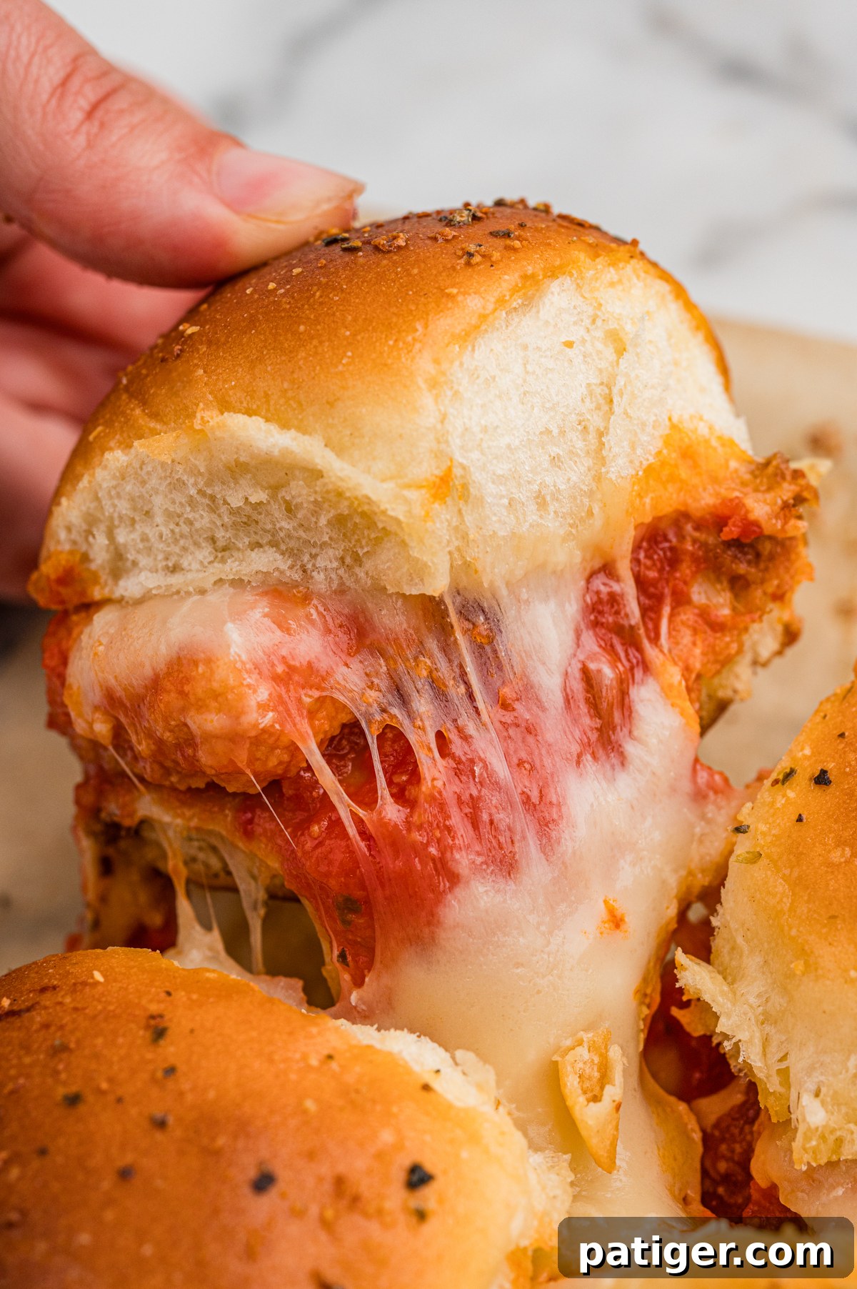 Pull apart Chicken Parm Sliders with chicken nuggets, showcasing the melty cheese and golden buns.