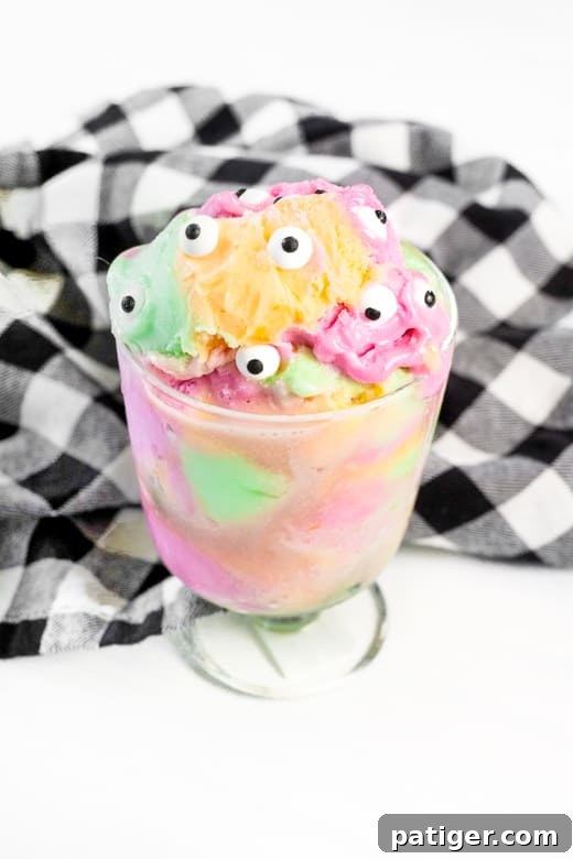 Rainbow sherbet topped with candy eyeballs, creating a fun and easy Halloween treat. A delightful and colorful dessert perfect for kids' parties.