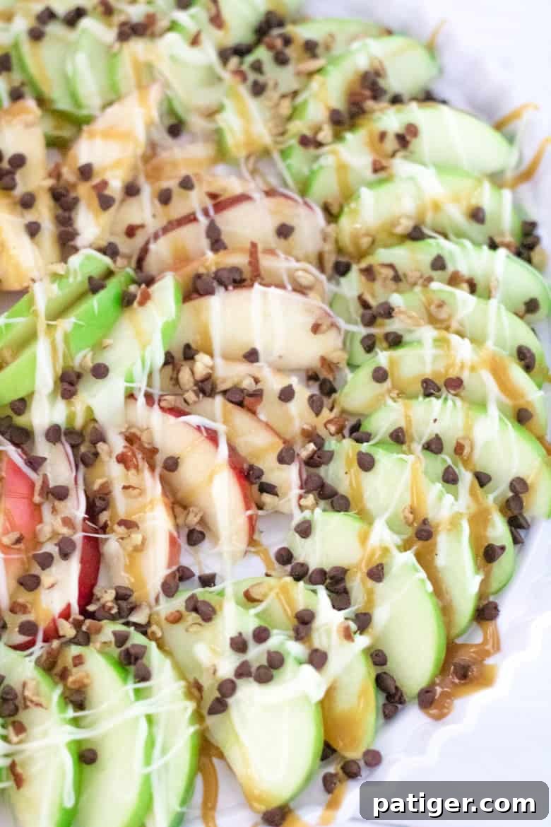Caramel apple nachos on platter, showcasing a vibrant and appealing arrangement of sliced apples with various toppings.