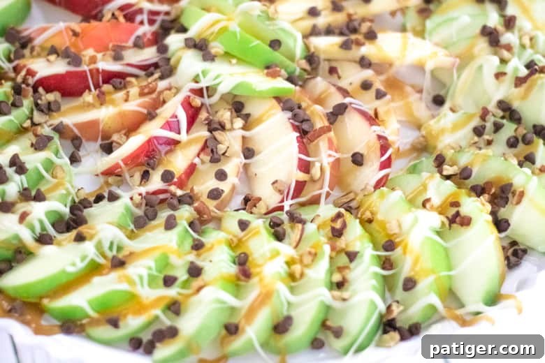 Loaded Caramel Apple Slices with melted white chocolate, caramel sauce, mini marshmallows, and chopped nuts. A decadent and inviting treat.