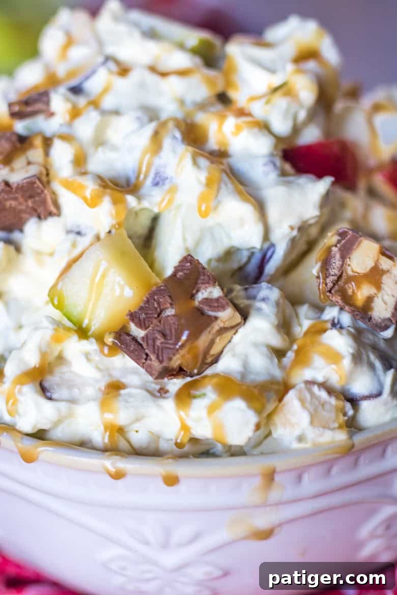 Ultimate Snickers Caramel Apple Salad 5 An overhead shot of Caramel Apple Dessert Salad, generously adorned with Snickers bars and a rich caramel drizzle, inviting viewers to indulge in this sweet and crunchy treat.