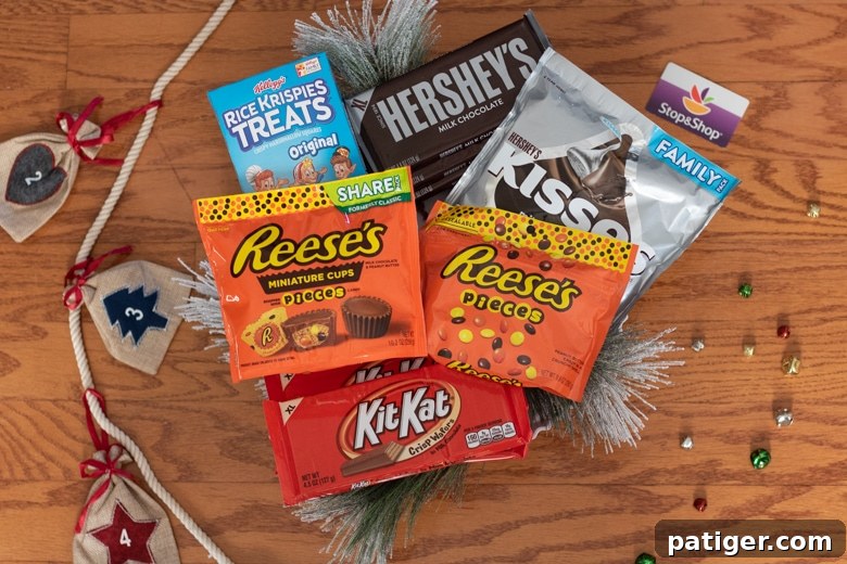 Festive Sweet Retreat 3 Candy Cabin Supplies: Rice Krispie Treats, Reese's Pieces, Reese's Peanut Butter Cups, Kit Kat Bars, Hershey bars, and Hershey Kisses.