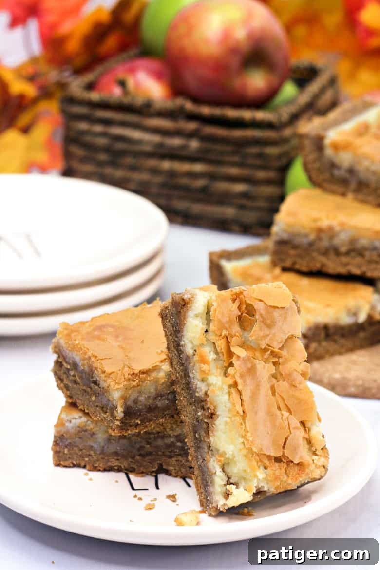 Cozy Autumn Spice Bars 2 Delicious harvest spice bars with a thick cream cheese layer, ready to be served on a plate, perfect for fall