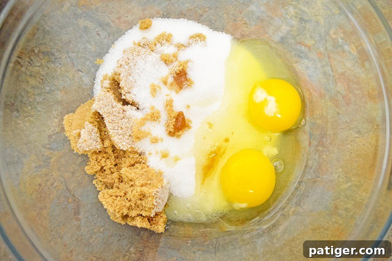 Heavenly Chocolate Chip Pumpkin Loaf 7 Wet ingredients for pumpkin chocolate chip bread being mixed in a bowl with a whisk.