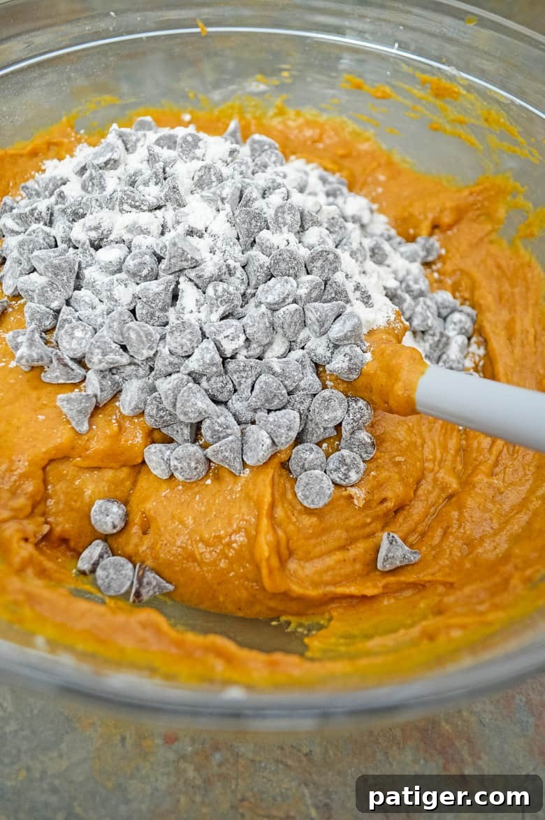 Heavenly Chocolate Chip Pumpkin Loaf 10 Chocolate chips being folded into the pumpkin bread batter in a large mixing bowl.