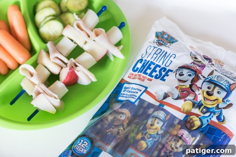 Kid-friendly Lunch Kebabs featuring PAW Patrol String Cheese, apple chunks, and turkey cold cuts.