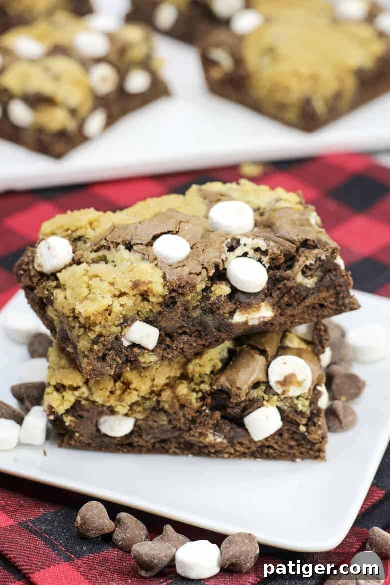 Cozy Hot Chocolate Brookies 2 Stack of freshly baked hot chocolate brookies on a white plate, showcasing their fudgy brownie base, chewy cookie topping, and melted marshmallow pockets, ready to be enjoyed.