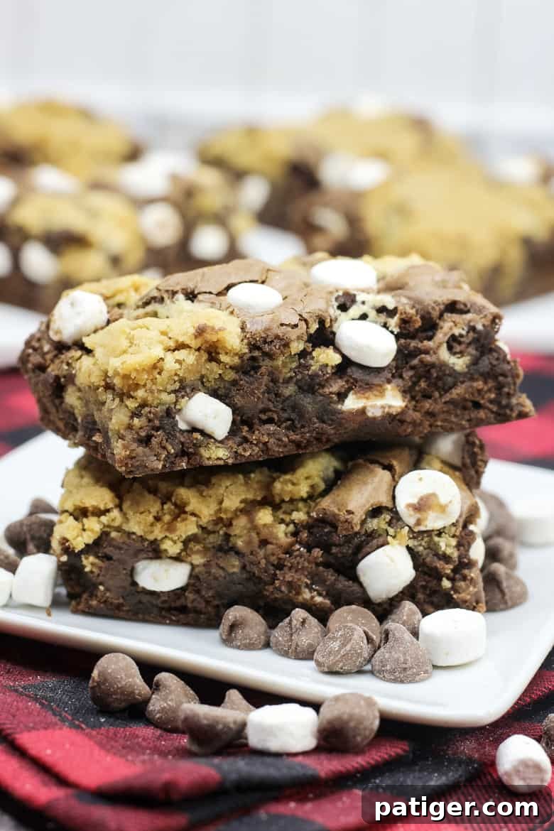 Cozy Hot Chocolate Brookies 5 A beautifully arranged stack of hot chocolate brookies, showing a perfect cross-section of the rich brownie, chewy cookie, and melty marshmallows, garnished with a sprinkle of cocoa powder.