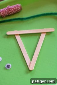 Three popsicle sticks glued together to form a triangular base for the reindeer face