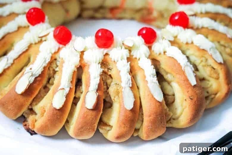 Swedish Tea Ring beautifully topped with creamy frosting, glazed cherries, and crunchy slivered almonds, ready to be served.