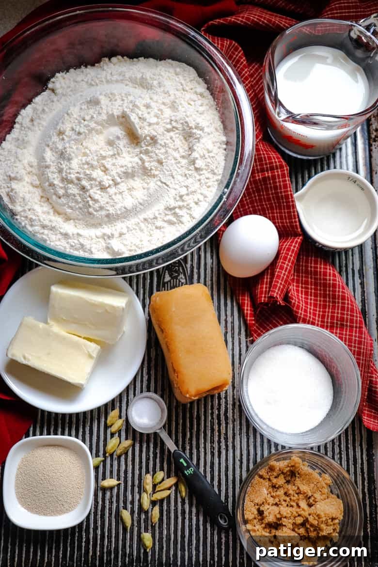 Essential ingredients for the Swedish Tea Ring dough, including flour, butter, egg, milk, sugar, almond paste, and yeast, neatly arranged.
