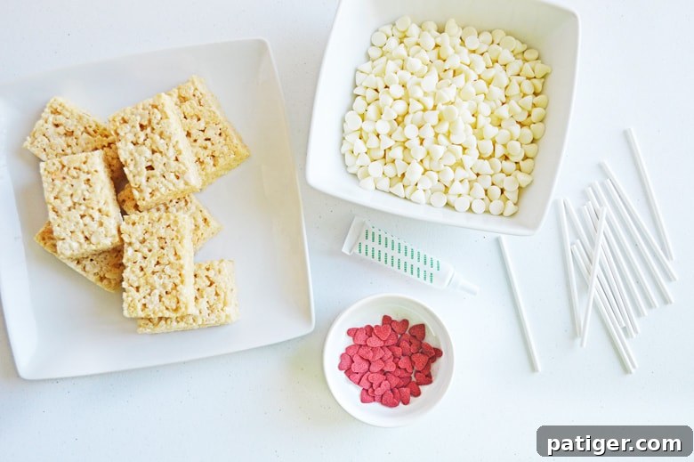 Grinch's Green Krispie Delights 4 Ingredients laid out: white chocolate chips, red heart sprinkles, and unwrapped Rice Krispie Treats, ready for assembly.