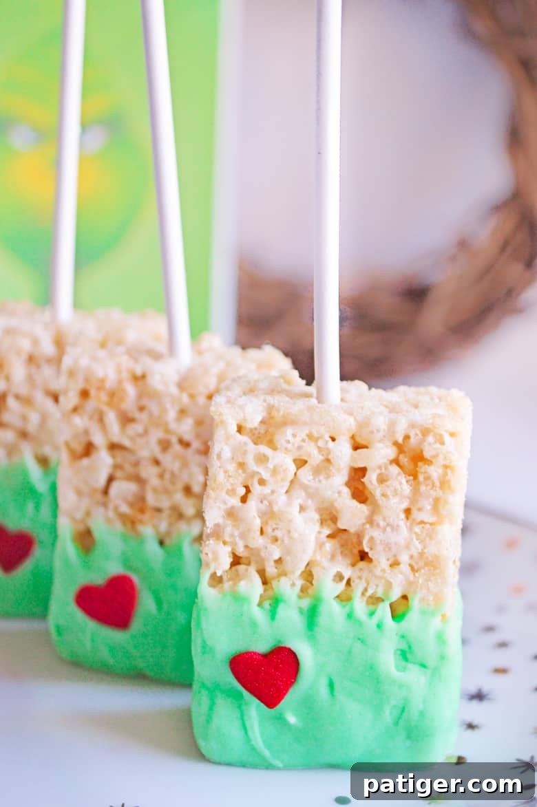Grinch's Green Krispie Delights 6 Finished Grinch Rice Krispie Treats, perfectly green with a single red heart, displayed for serving.