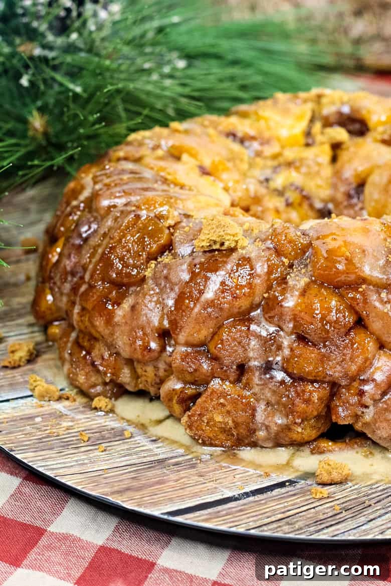 Gingerbread Monkey Bread, golden brown and glistening with glaze, ready to be served on a festive plate.