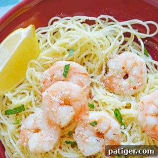 shrimp scampi over angel hair pasta served with a lemon wedge and topped with parsley