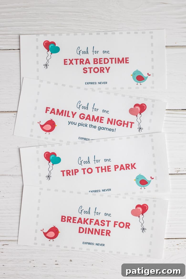 A hand holding a stack of colorful Valentine's Day coupons for kids, showing various activities. The focus is on the festive and fun design of the printable coupons.