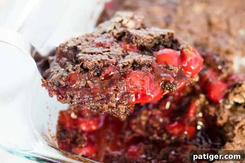 Velvet Cherry Chocolate Bake 3 Chocolate cherry dump cake being scooped up with serving spoon.