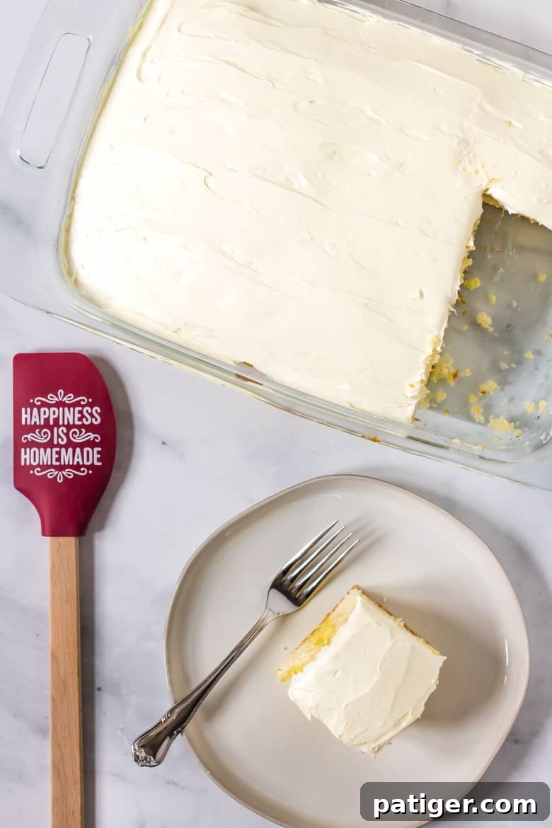 Lemon sheet cake with a slice cut out and served on a plate, showing the Jello inside