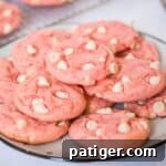 Strawberry cake mix cookies with white chocolate chips on a white plate.