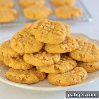 Cheese Cookies on a white plate with cookie on cooling rack in background