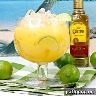 Hawaiian Margarita Cocktail with bottle of Jose Cuervo tequila and limes in background
