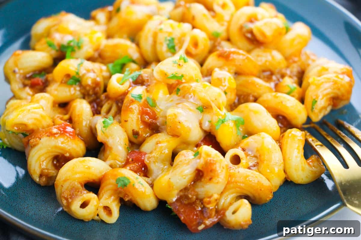 cavatappi pasta with ground beef, red sauce, melted cheese, and fresh cilantro
