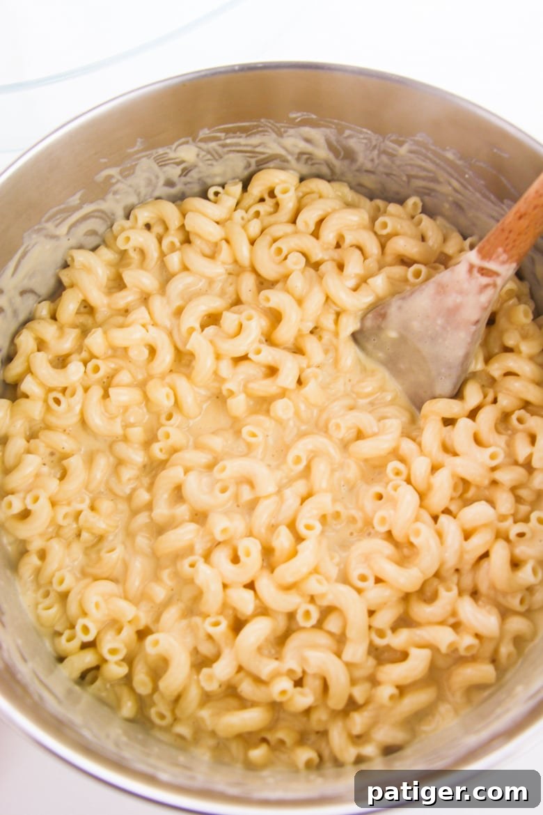 Large pot of perfectly cooked elbow macaroni mixed with a rich, creamy cheese sauce, ready for baking
