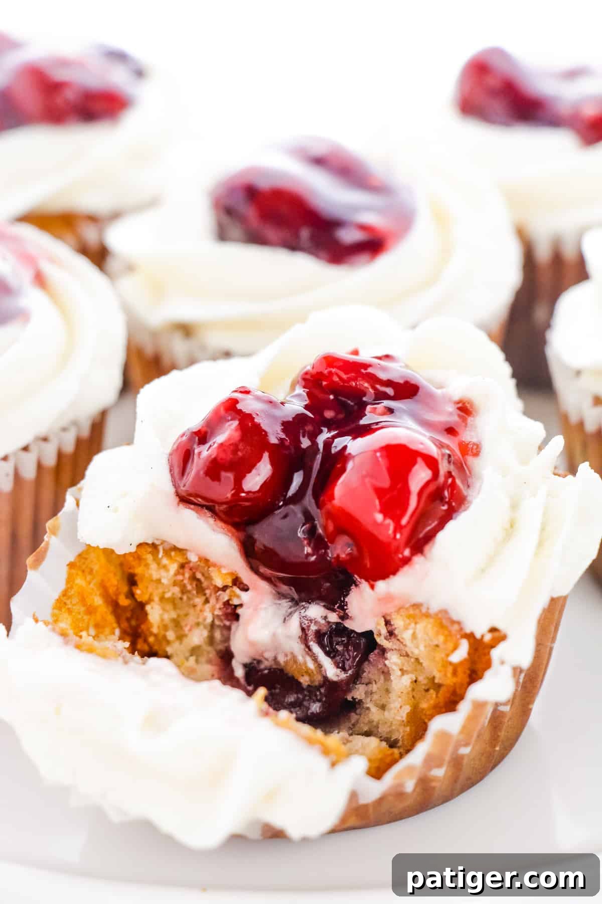 Cross-section of a Cherry Pie Cupcake showing the sweet cherry filling baked inside the vanilla cake