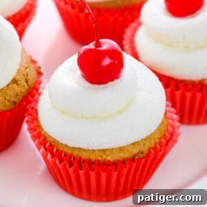Root Beer Cupcakes topped with buttercream and maraschino cherries