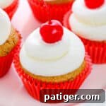 Root Beer Cupcakes topped with buttercream and maraschino cherries