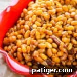 Ultimate Boston Baked Beans 11 Boston baked beans with bacon in a red dish.