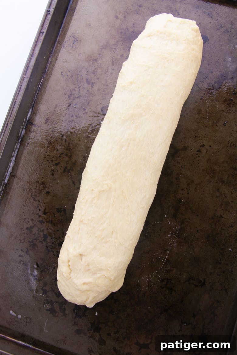 Aromatic Italian Herb Loaf 5 Bread dough formed into a long log on a baking sheet