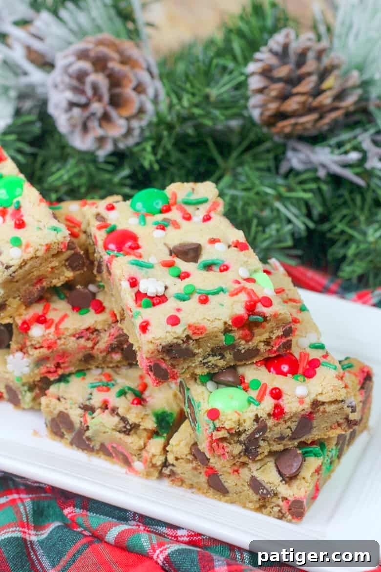 Holiday Cookie Bar Delights 2 Festive Christmas Cookie Bars loaded with red and green M&M's, semi-sweet chocolate chips, and colorful sprinkles, ready to be enjoyed.