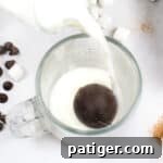 Hot Chocolate Bomb in glass with milk being poured over it