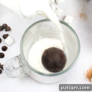 Hot Chocolate Bomb in glass with milk being poured over it