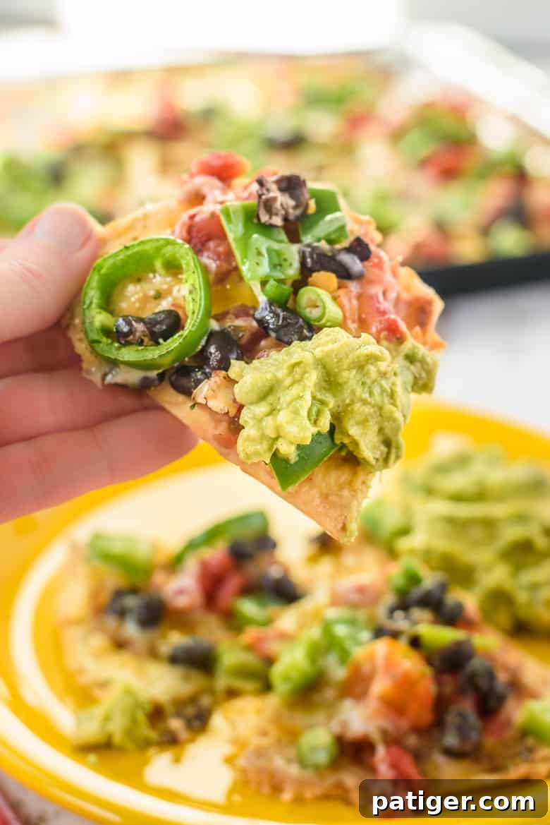 Delicious vegetarian nachos with beans, peppers, cheese, and guacamole ready to be served