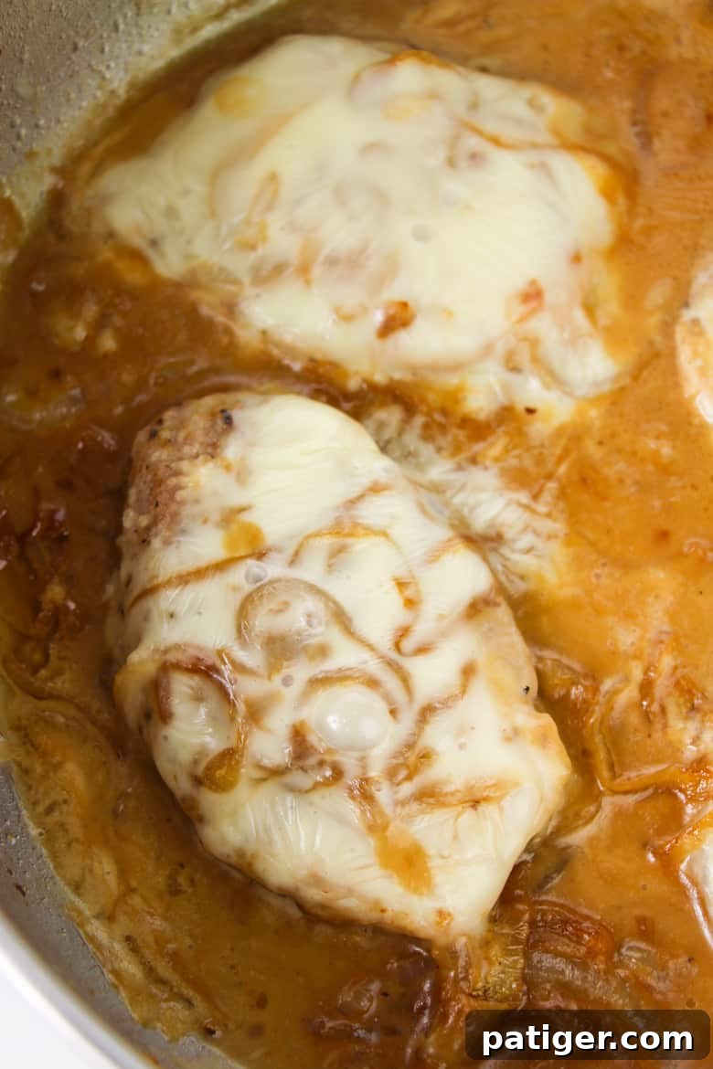 French Onion Pork Chops simmering in pan with gravy