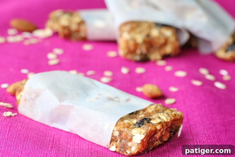 Cherry almond granola bars neatly wrapped in parchment paper, showcasing their wholesome texture and portability.