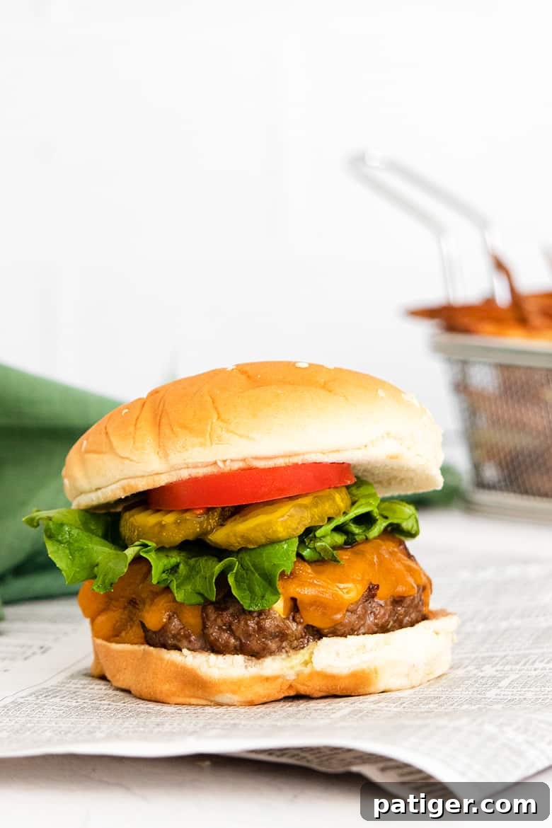Thick cheeseburger with fries in the background
