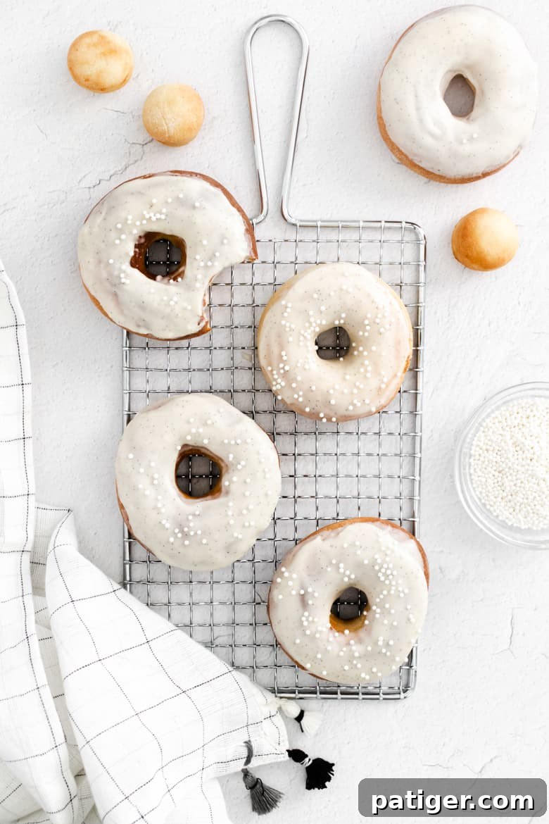 Homemade Air Fryer Doughnut Delights 2 Air fryer donuts made from scratch with vanilla icing and sprinkles, beautifully arranged on a cooling rack.