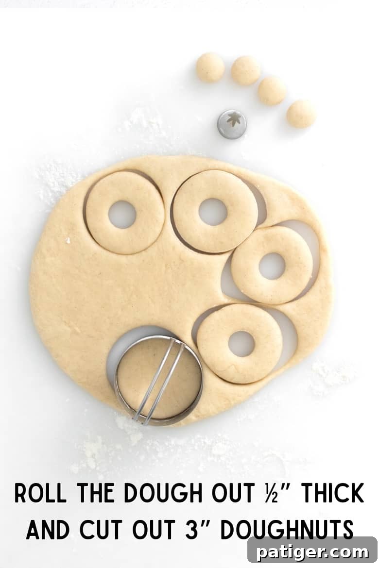 Homemade Air Fryer Doughnut Delights 8 Dough rolled out on a floured surface, being cut into 3-inch circles with a hole in the middle using a donut cutter.