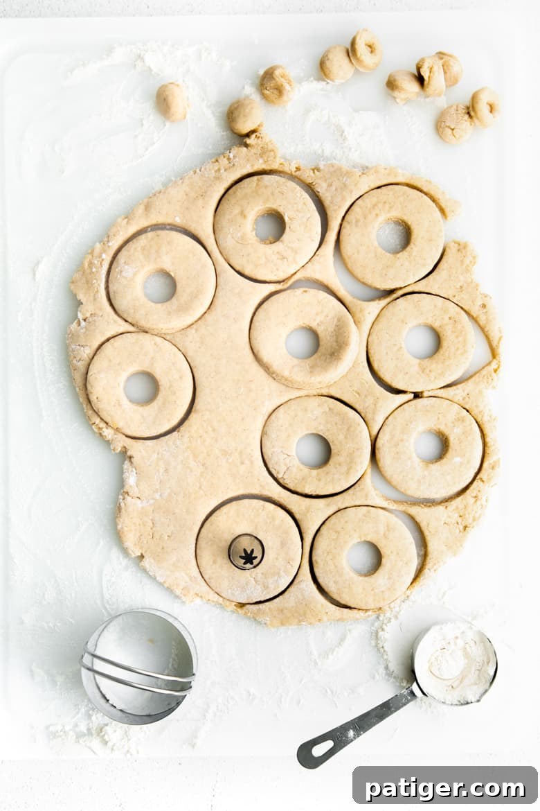 Doughnuts being cut out of dough using biscuit cutter and piping tip