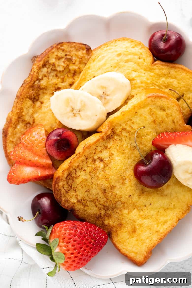 Overhead image of 3 slices of french toast topped with banana slices and berries