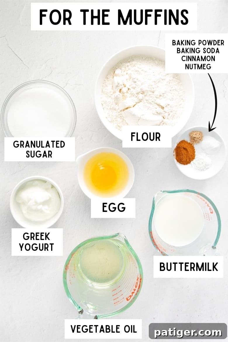 Bowls of muffin ingredients on a table, each labeled: granulated sugar, flour, Greek yogurt, egg, buttermilk, vegetable oil, baking soda, baking powder, cinnamon, and nutmeg, with a label 'For the Muffins'.